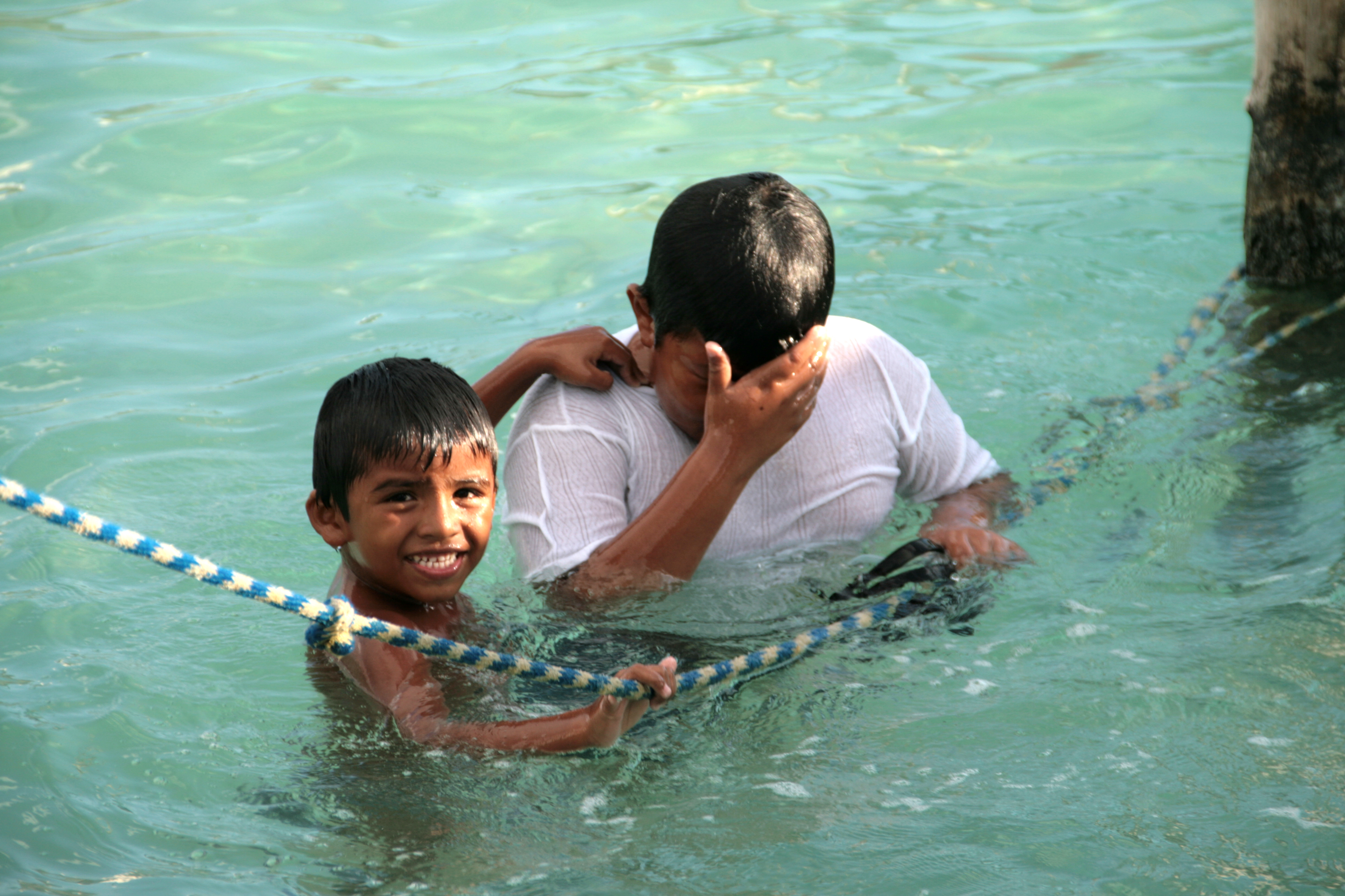 Dos niños se refrescan en el puerto de Isla Mujeres.